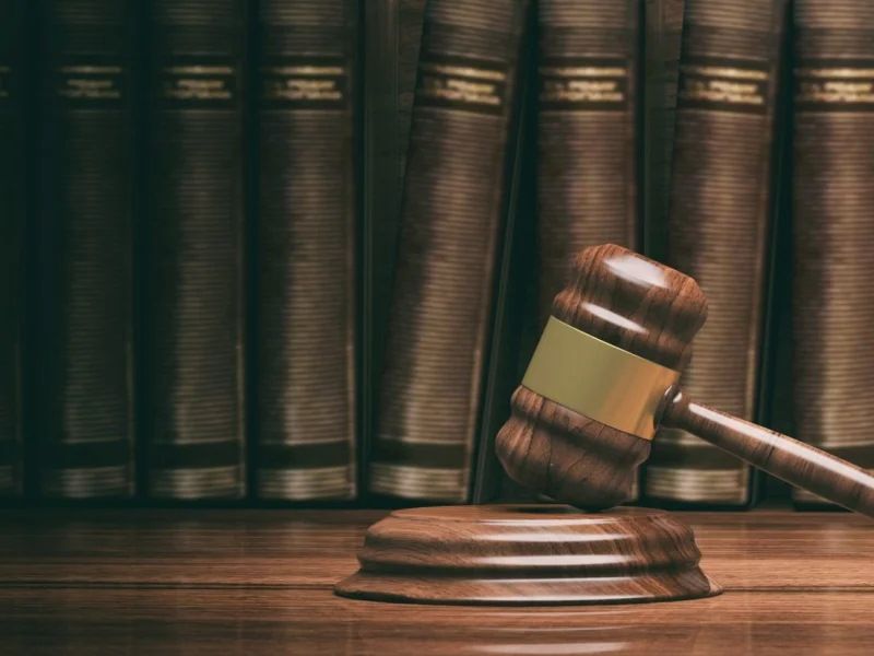 Ein Richterhammer liegt auf einem Tisch vor mehreren Gesetzesbüchern bei einem Anwalt für Familienrecht in Meppen.